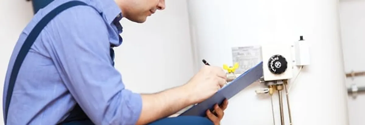 Water heater repair technician inspecting the unit and recording service notes in Los Angeles, CA